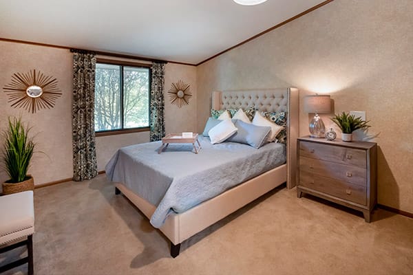 A cozy bedroom with a stylish bed, soft lighting, and elegant decor.