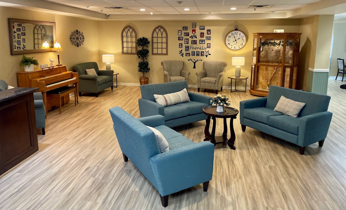 A cozy living room with blue sofas and armchairs arranged around a coffee table.
