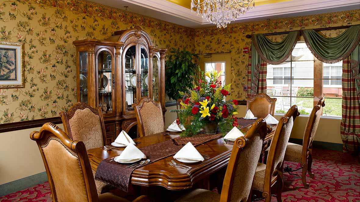 A traditional dining room with elegant wood furniture and a chandelier.