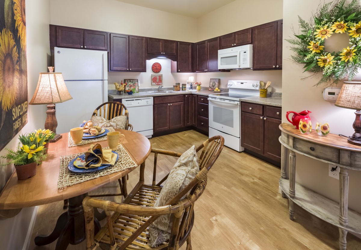 A cozy kitchen and dining area with wooden cabinets, set for a meal.