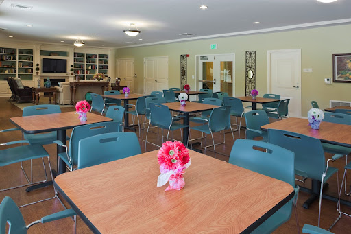 A well-arranged dining area featuring tables adorned with flowers, designed for community gatherings.
