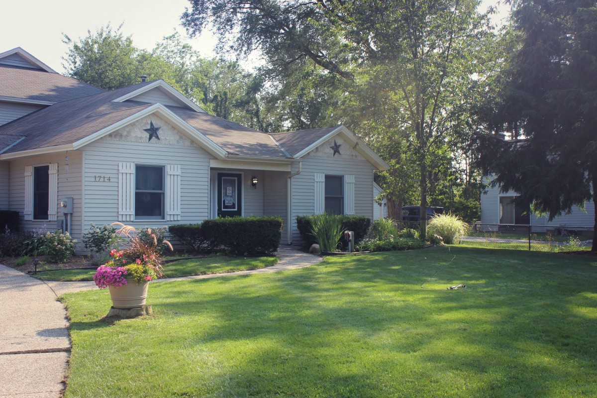 A quaint house with a well-maintained lawn and garden.