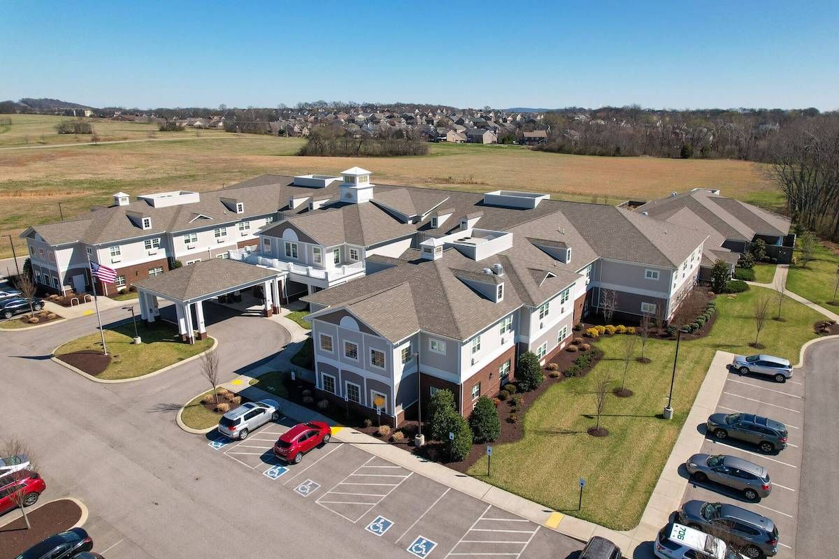 Aerial view of a large building with surrounding parking and landscaped areas.