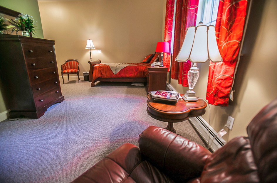 A cozy bedroom with red accents and elegant lighting.