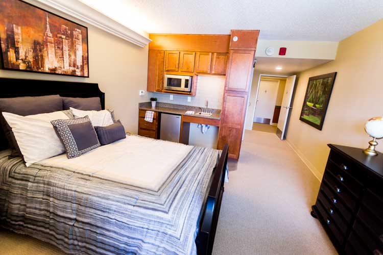 Modern studio apartment with a cozy bedroom and kitchenette.