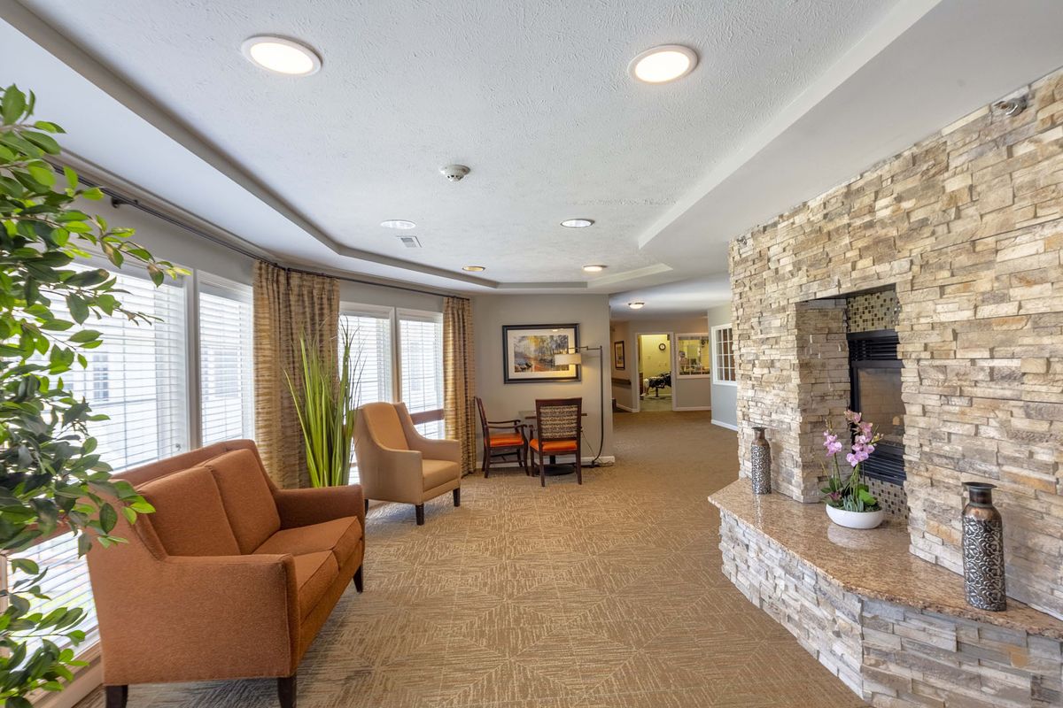A cozy living room with comfortable seating and a stone fireplace.