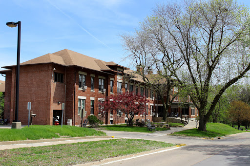 A brick building surrounded by trees and greenery, showcasing a peaceful outdoor environment in spring.