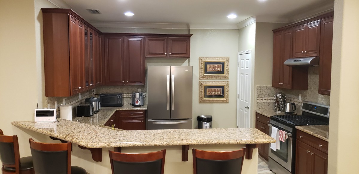 A modern kitchen with a granite countertop and stainless steel appliances.