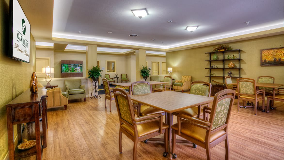 A cozy dining and lounge area with tables, chairs, and soft lighting.
