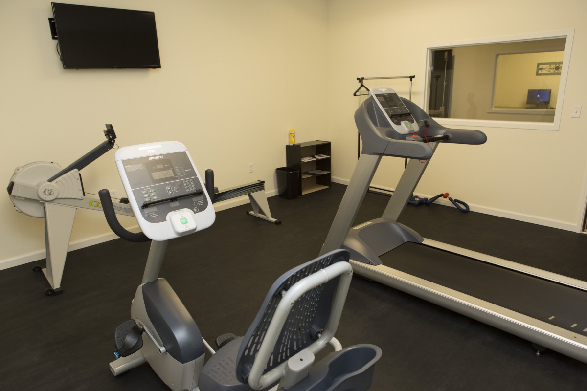 A small gym with a treadmill and stationary bike for exercise.
