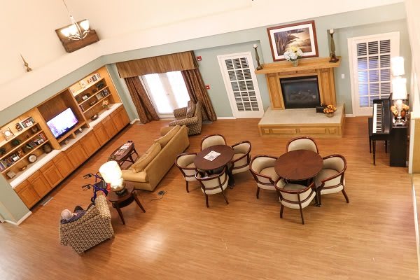 An overhead view of a spacious living room featuring elegant furniture, wood flooring, and a cozy fireplace.