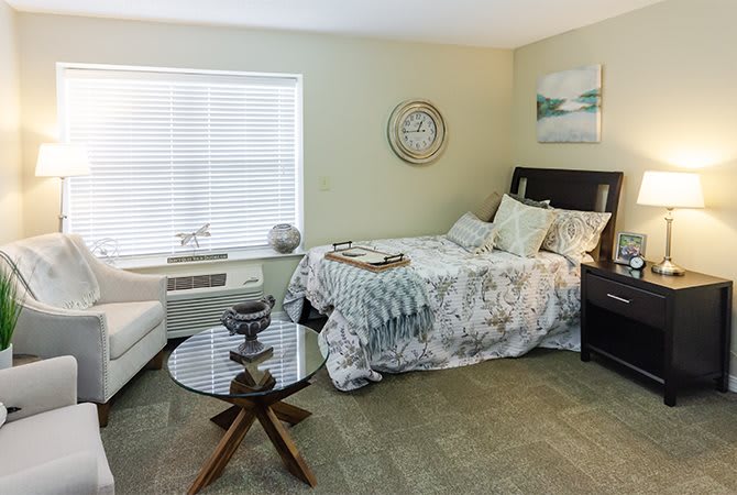A cozy bedroom with modern decor, featuring a bed, sofa, and coffee table.
