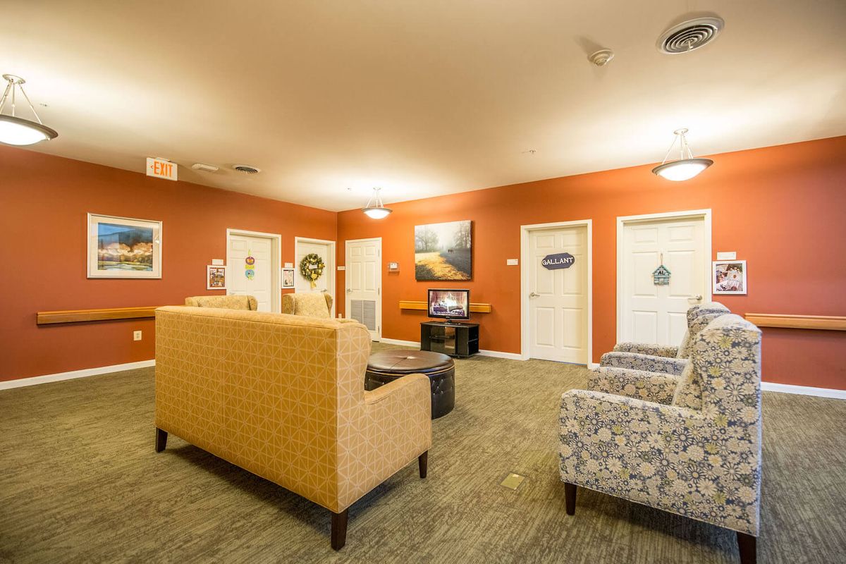 A cozy living room interior with multiple sofas, chairs, and wall art.