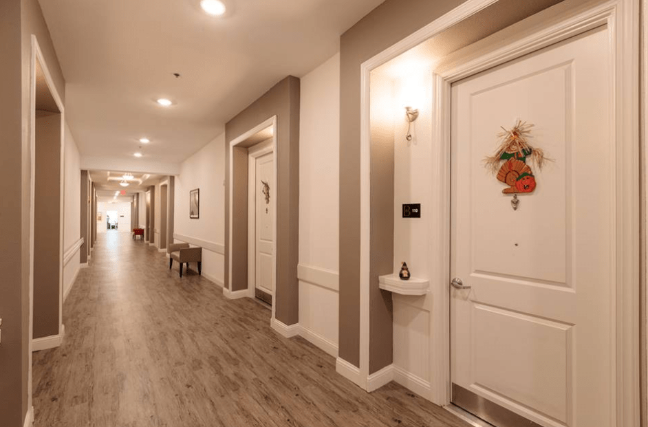 A well-lit hallway with decorative doors and wooden flooring.