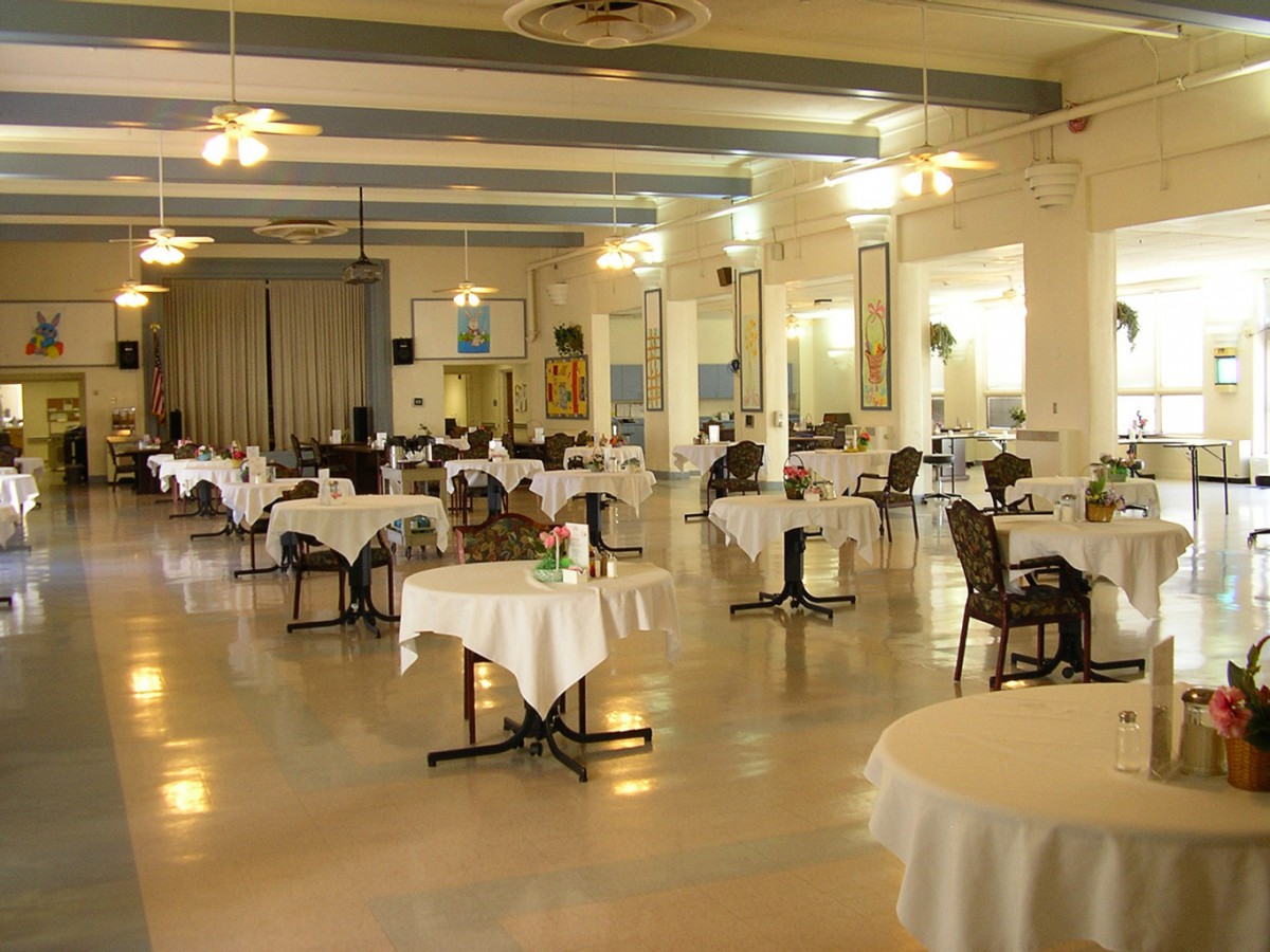 A spacious and elegantly arranged restaurant dining area with round tables and chairs.