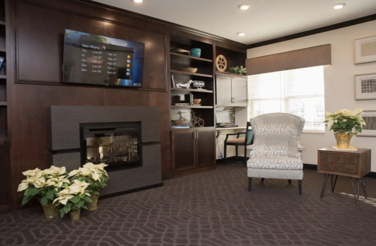 A cozy living room featuring a fireplace, television, and comfortable armchair.