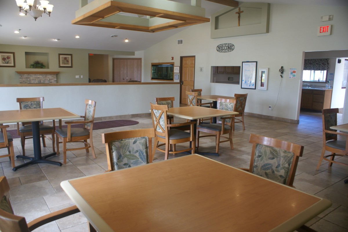 An empty dining area with wooden tables and chairs.