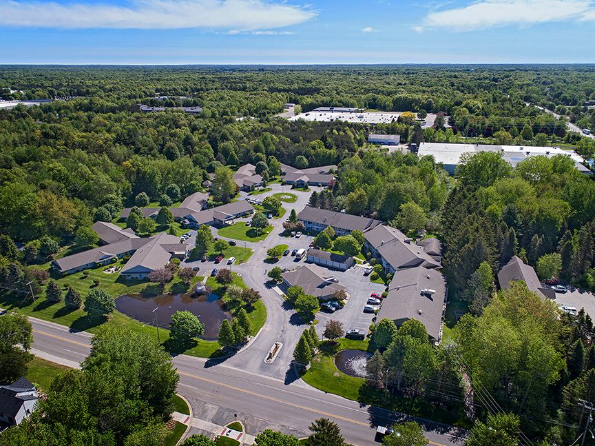 Aerial view of a suburban housing complex surrounded by trees.