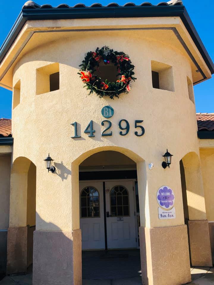 The entrance of a building with the address number 14295 adorned with a festive wreath.