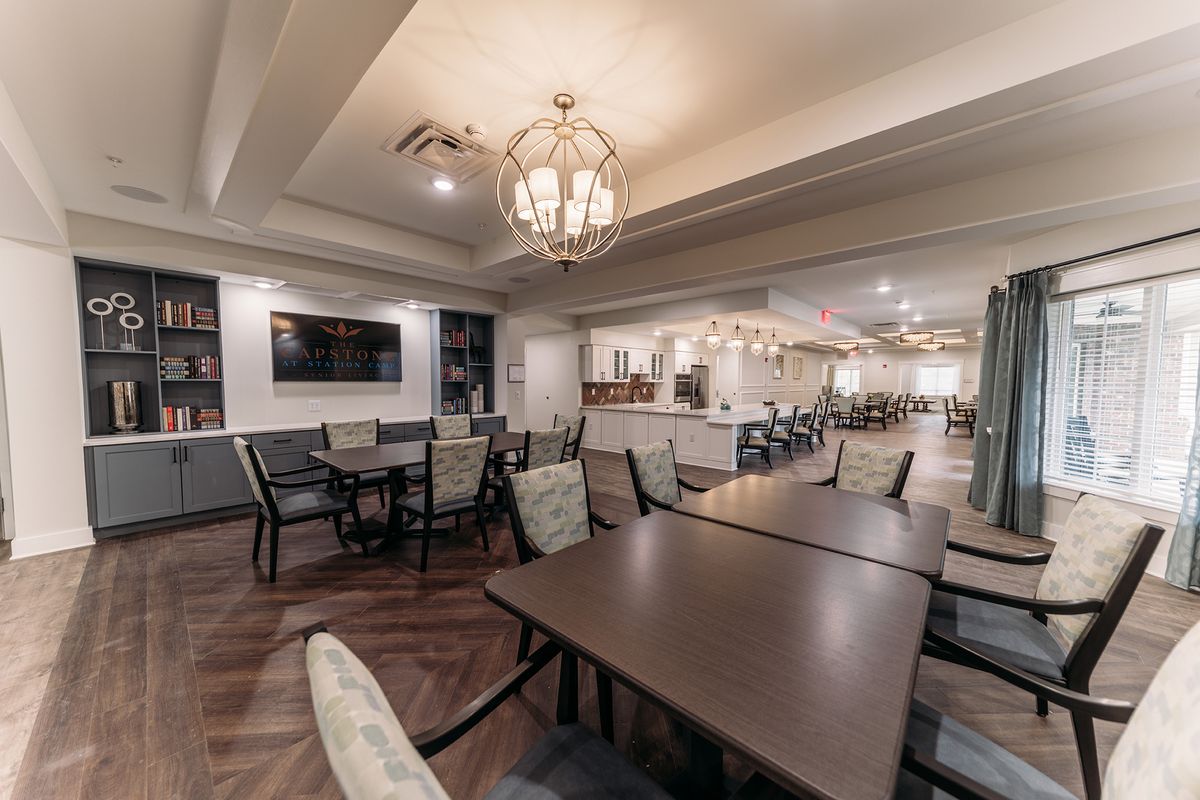 A modern dining area with elegant chandeliers, comfortable seating, and stylish decor.