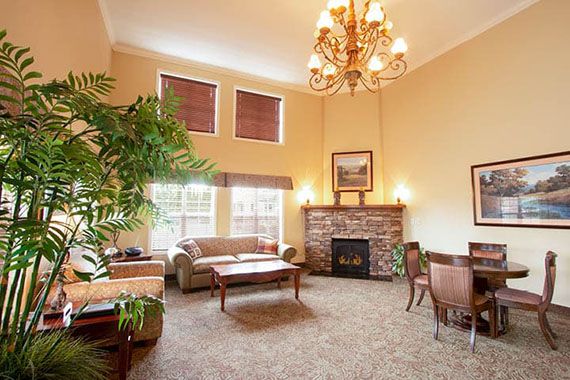 A cozy living room with elegant furnishings, featuring a chandelier and fireplace.