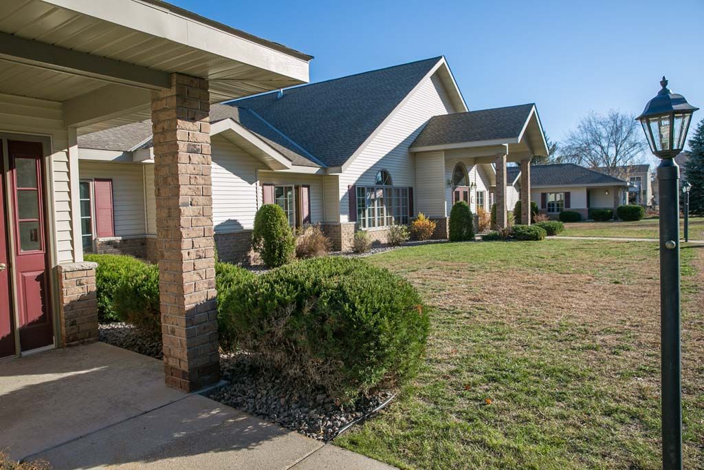 A row of modern suburban houses with manicured lawns and bushes.