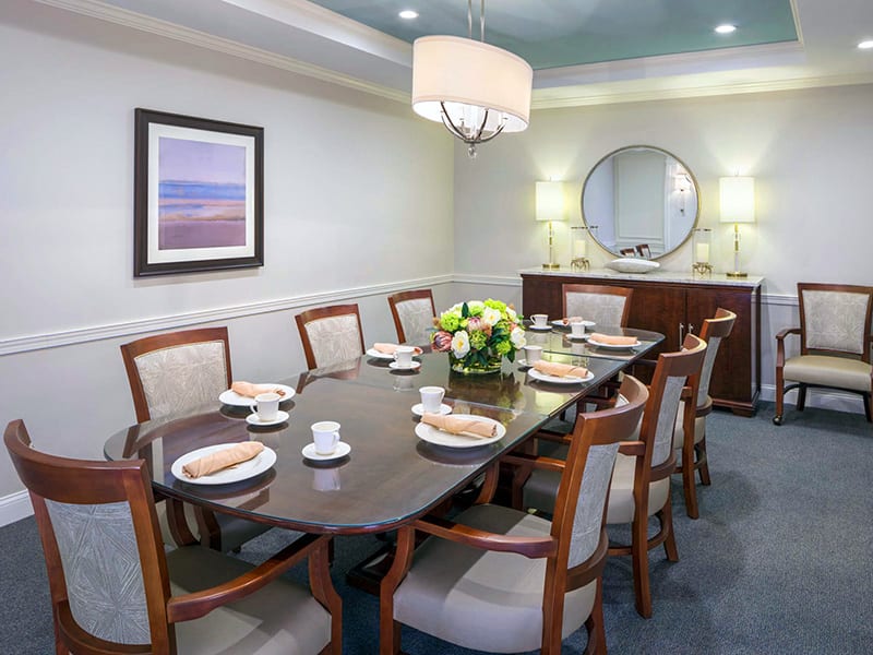A well-decorated dining room with a set dining table, surrounded by chairs and elegant decor.
