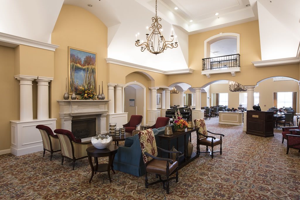 A luxurious lobby area featuring elegant seating, a grand chandelier, and a decorative fireplace.