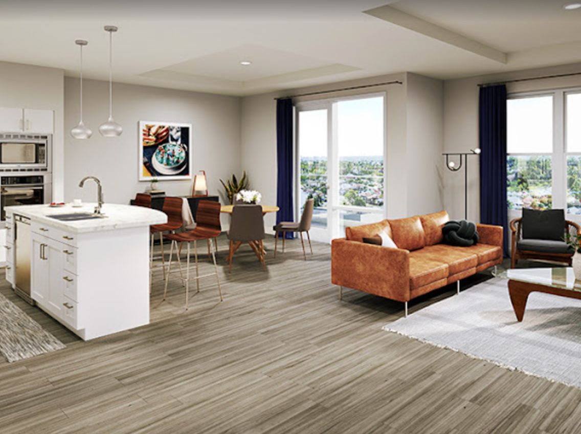 A modern open-concept living and dining area featuring a kitchen island, a comfortable sofa, and stylish decor.