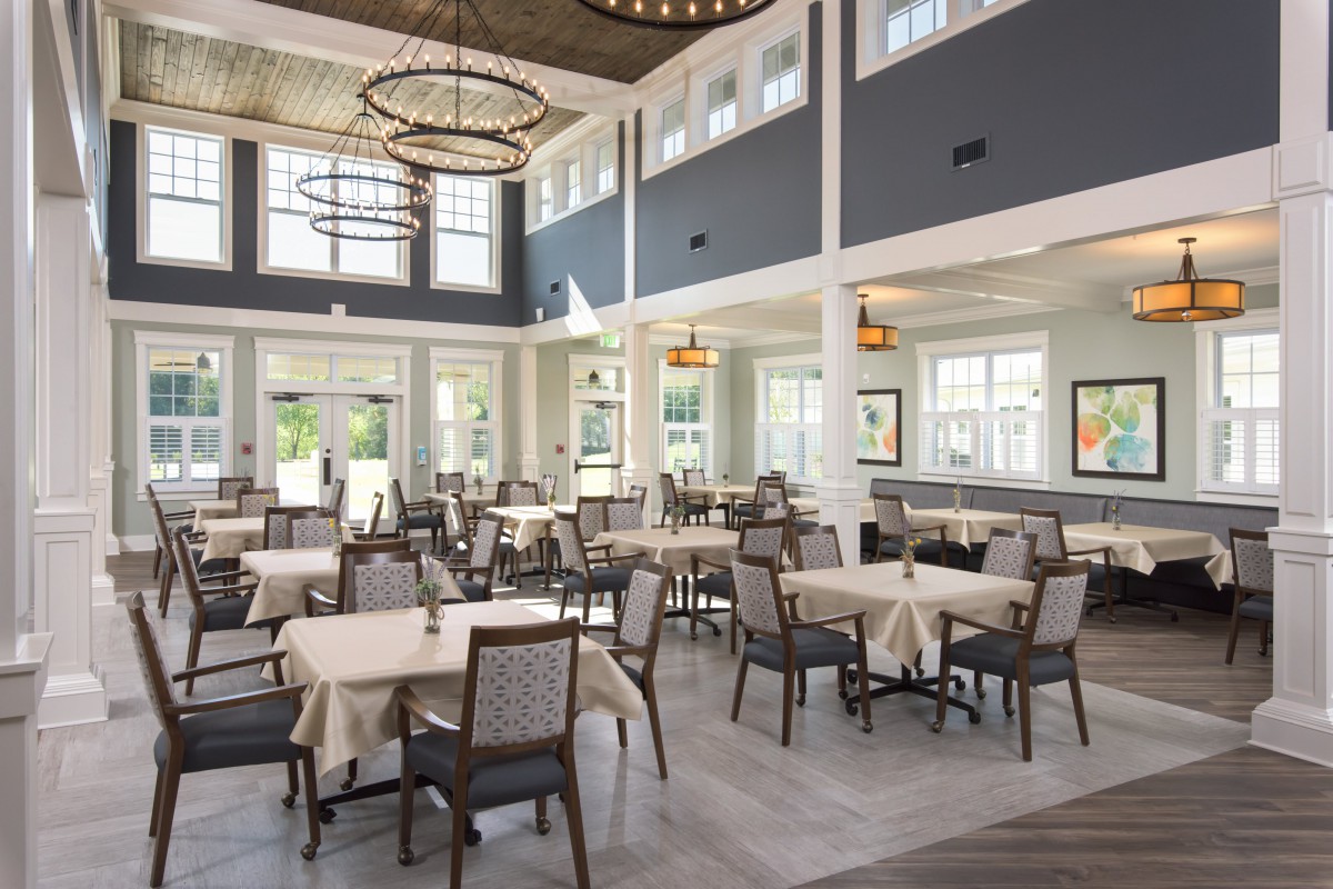 An elegant dining area with neatly arranged tables and chairs, featuring modern lighting and spacious interiors.