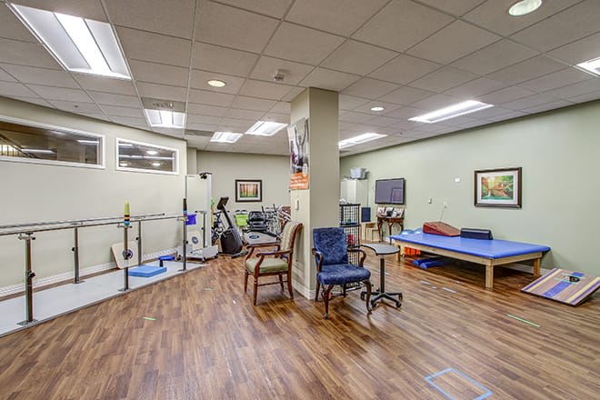 A well-equipped physical therapy clinic with various exercise equipment and treatment areas.