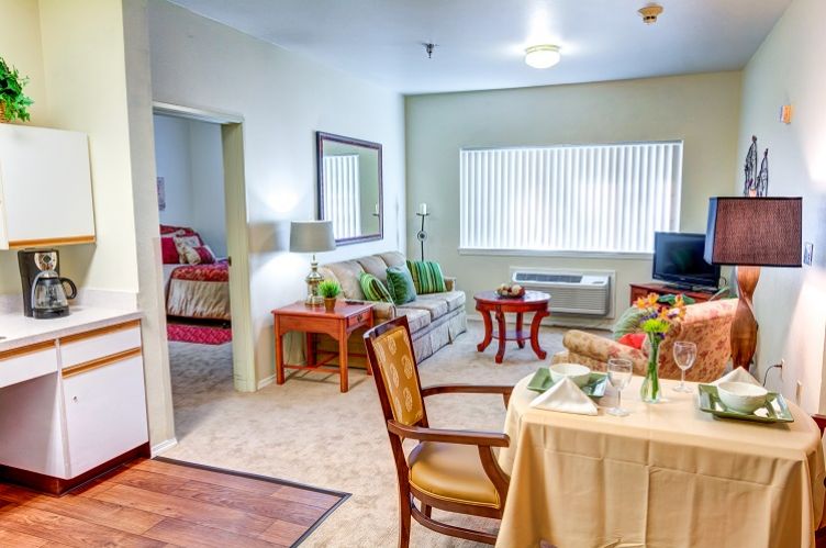 A cozy apartment interior featuring a living room with a sofa and a dining area.