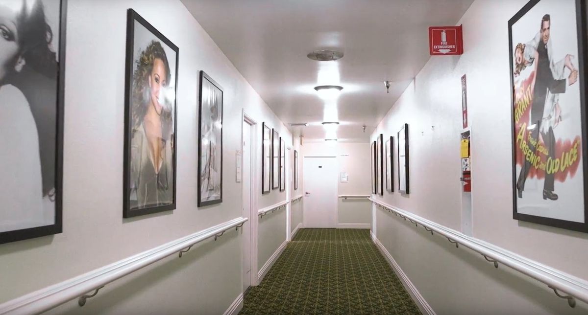 A well-lit hallway featuring framed artwork on the walls.