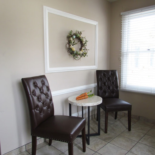 A cozy corner with elegant chairs and a decorative wreath on the wall.