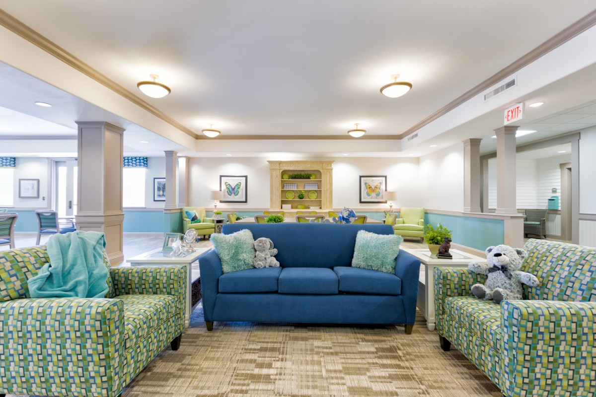 A cozy and modern living room with a blue sofa and patterned armchairs.