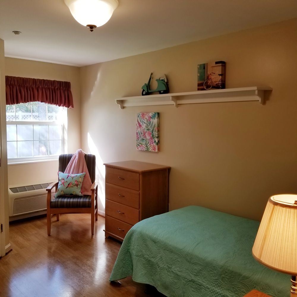 A cozy bedroom with a single bed, window, and simple decor.