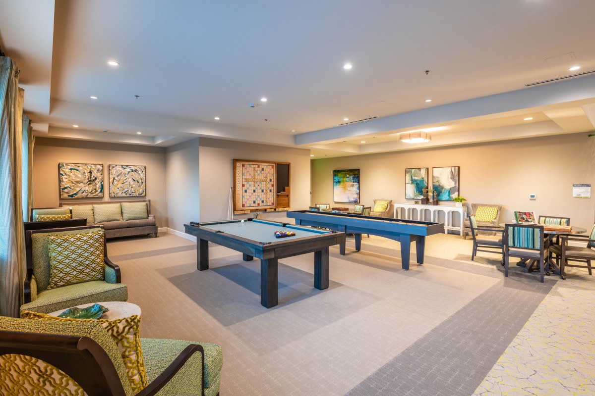 A modern game room featuring pool tables and stylish seating.
