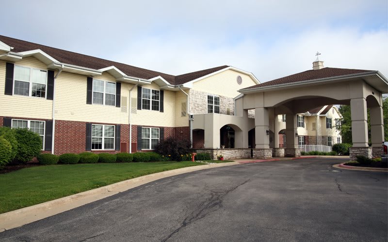 A two-story residential building with a driveway and entrance.