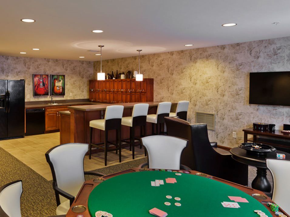 A stylish entertainment room featuring a bar and poker table, perfect for hosting games and social gatherings.