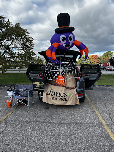 A festive Halloween setup featuring a large inflatable spider wearing a top hat, ready for trunk or treat activities.