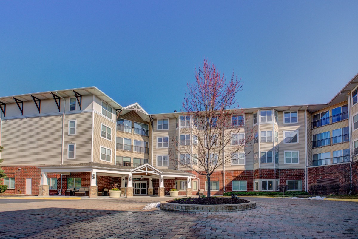 A modern residential apartment building under a clear blue sky.