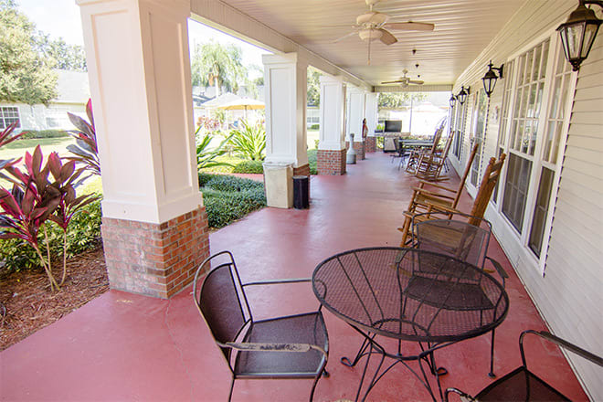 A spacious porch with outdoor seating and a garden view.