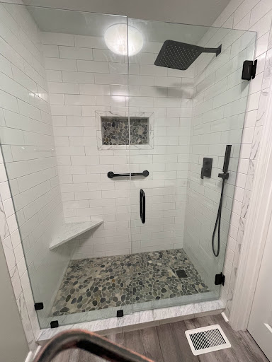 A modern, stylish shower featuring a glass enclosure and elegant tile work.