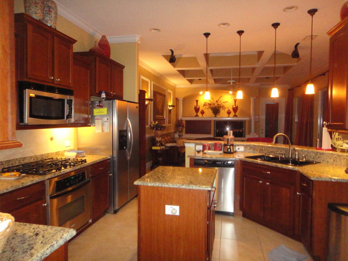 A modern kitchen with wood cabinets, stainless steel appliances, and an island.