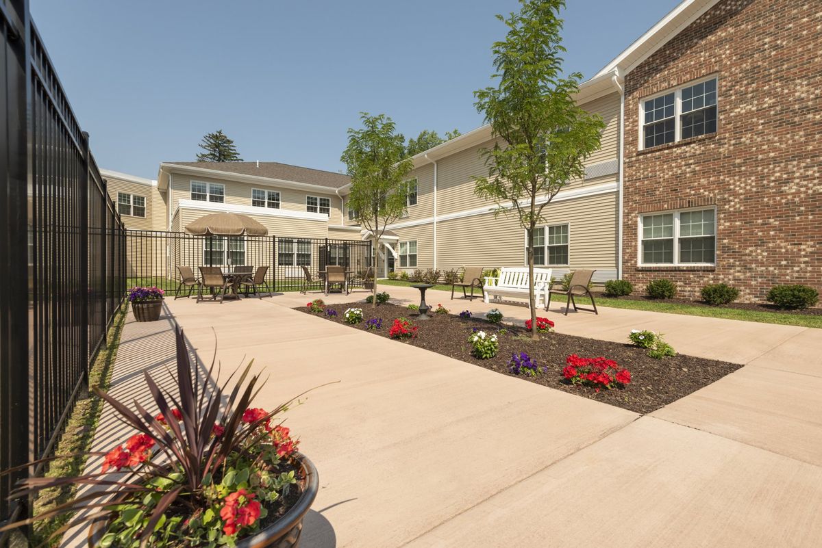 A well-maintained courtyard with flowers and seating area in front of a building.