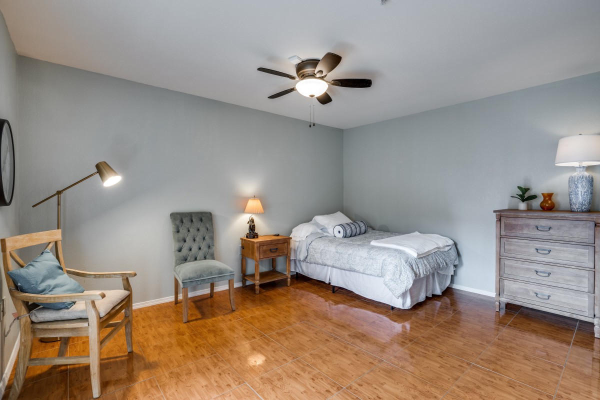 A cozy bedroom with a single bed, hardwood floors, and calming decor.