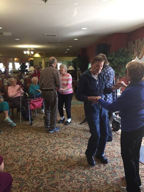 A group of seniors enjoying a dance at a community event.