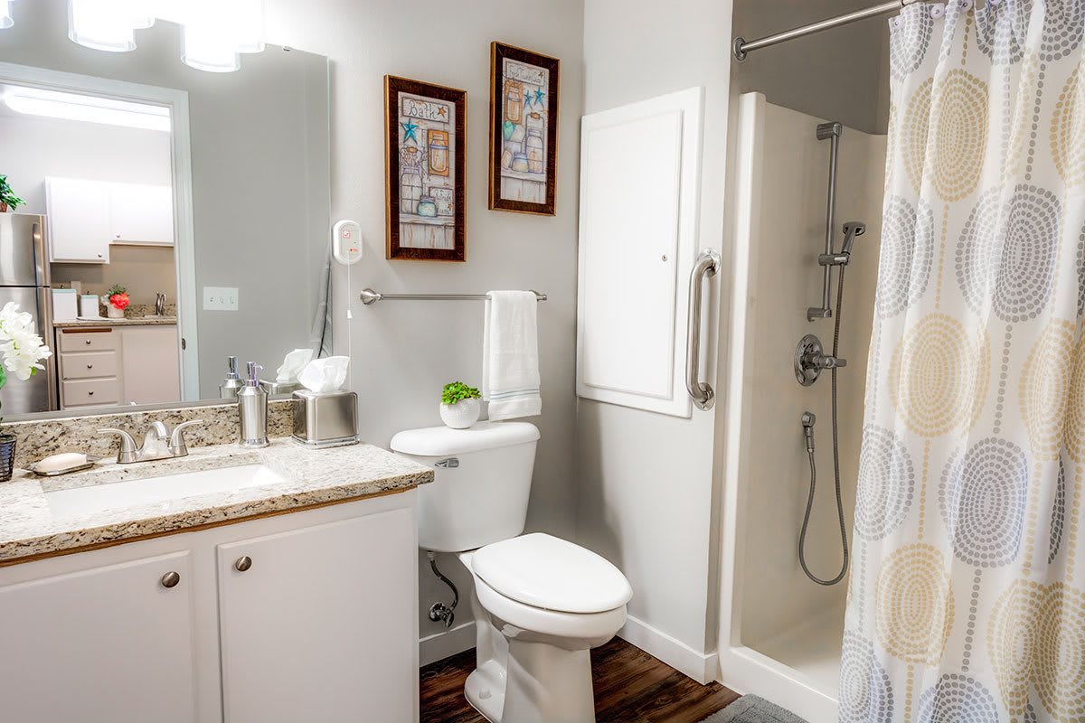 A modern bathroom with a shower, toilet, and sink.