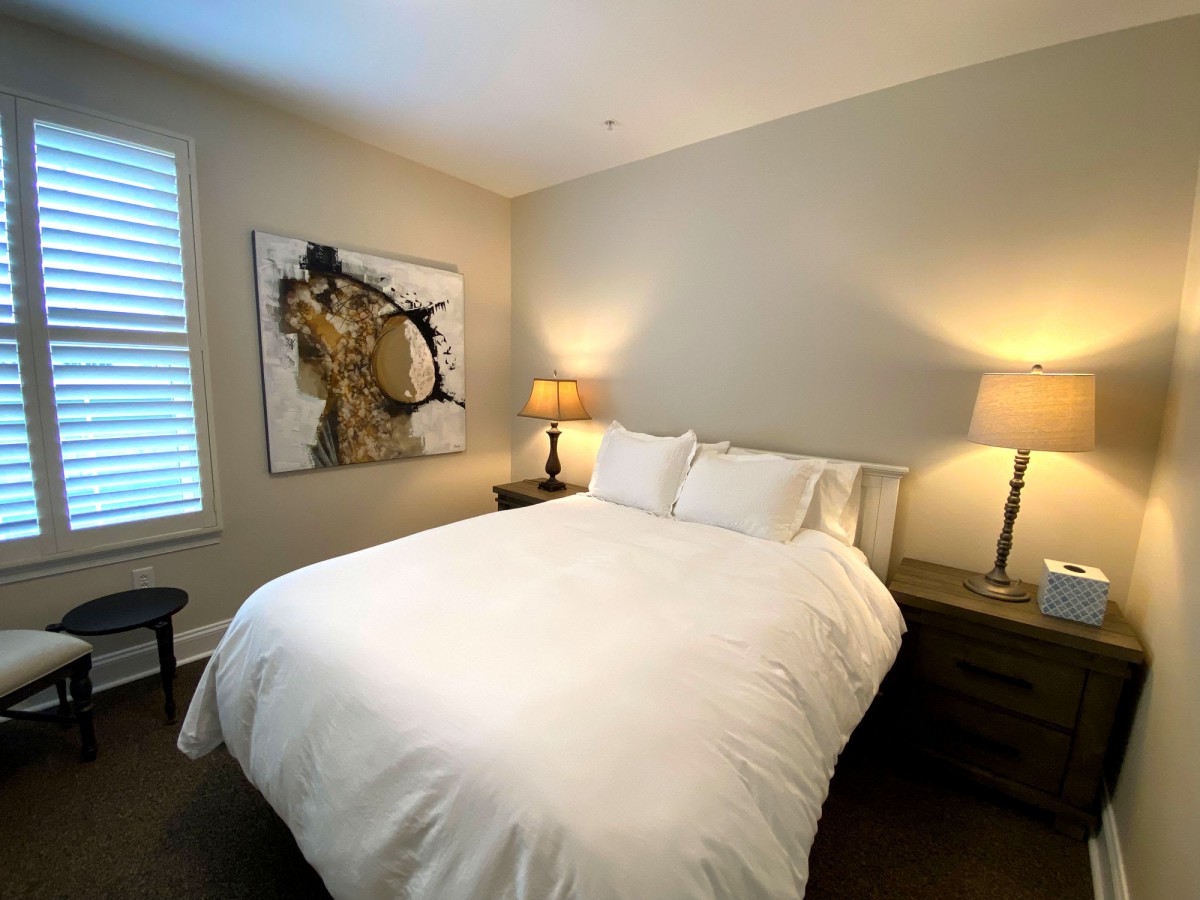 A modern bedroom with a neatly made bed and contemporary decor.