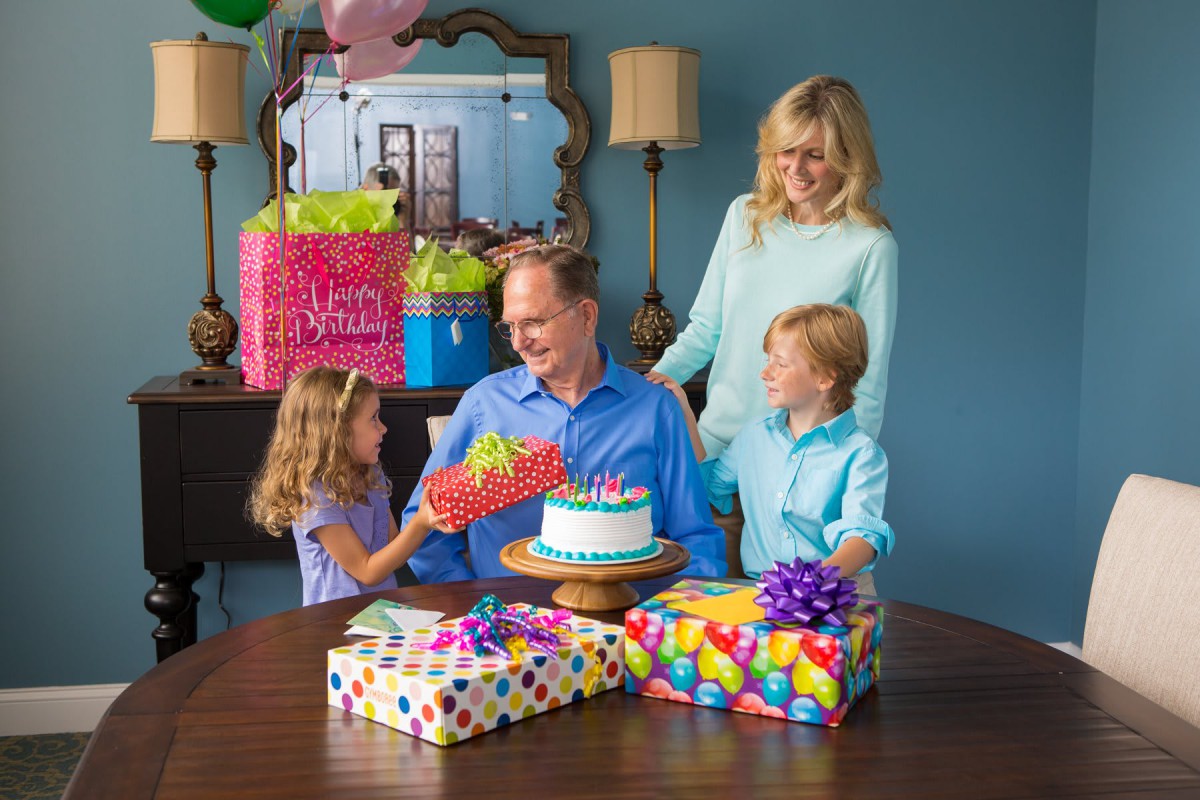 A family celebrating a birthday with cake and gifts.